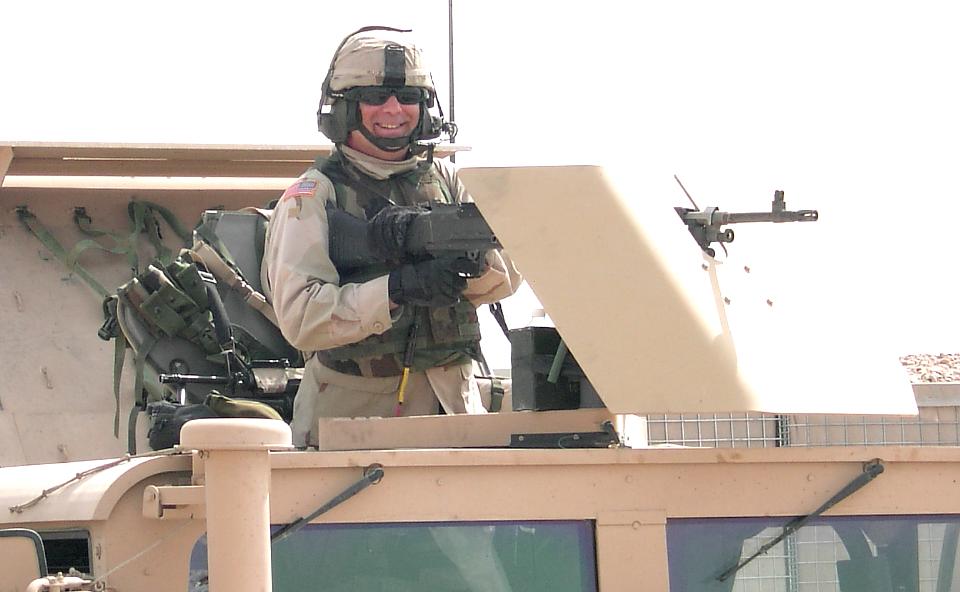 Photograph of Steve Ruiz manning the Humve machine gun in Iraq. Photograph by an American soldier of C Co, 1/252 Army Reserve Battalion. 