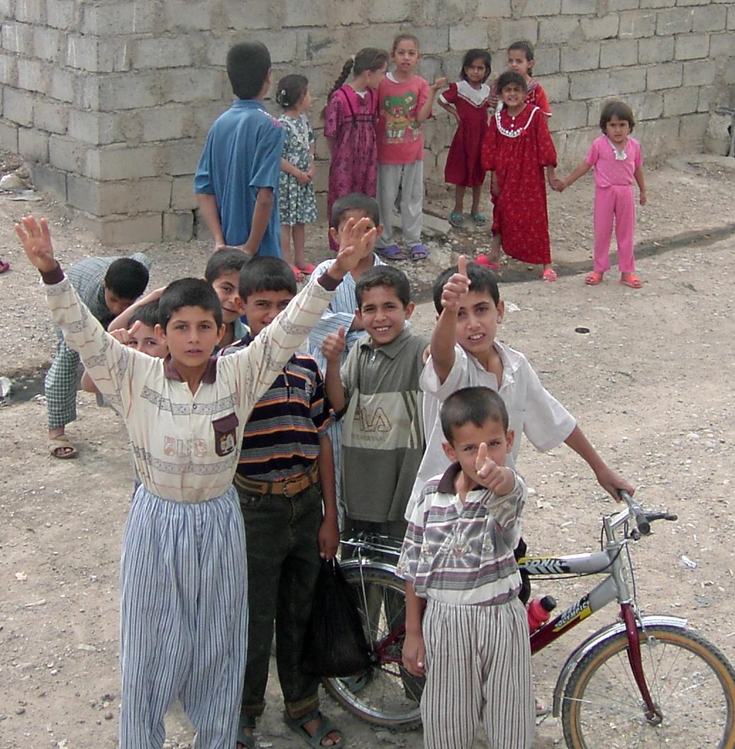 Photograph of Iraqi children with the boys in the foreground giving the thumbs-up signal. Photograph by an American soldier of C Co, 1/252 Army Reserve Battalion. 